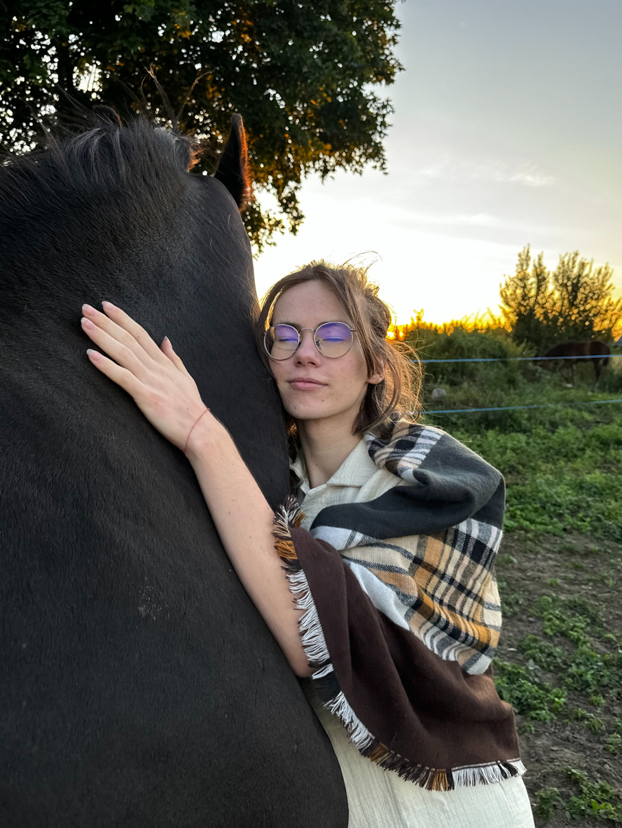 Człowiek przytula konia. Pokazuje to więź konia z człowiekiem